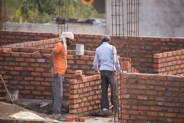 MUMBAI, MAHARASHTRA, INDIA 12 Kasım 2019: İnşaat işçileri bir inşaat sahasında çalışıyor. Hindistan 'da inşaat işçileri iş yerinde güvenlik önlemi almıyorlar..