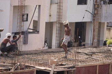 MUMBAI, MAHARASHTRA, INDIA 12 Kasım 2019: İnşaat işçileri bir inşaat sahasında çalışıyor. Hindistan 'da inşaat işçileri iş yerinde güvenlik önlemi almıyorlar..