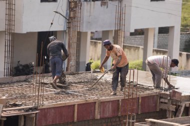 MUMBAI, MAHARASHTRA, INDIA 12 Kasım 2019: İnşaat işçileri bir inşaat sahasında çalışıyor. Hindistan 'da inşaat işçileri iş yerinde güvenlik önlemi almıyorlar..