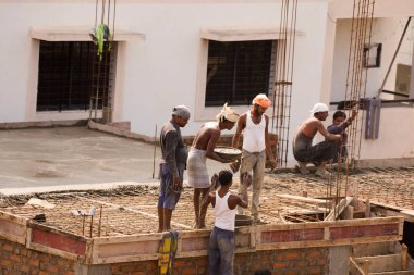 MUMBAI, MAHARASHTRA, INDIA 12 Kasım 2019: İnşaat işçileri bir inşaat sahasında çalışıyor. Hindistan 'da inşaat işçileri iş yerinde güvenlik önlemi almıyorlar..