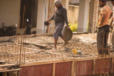 MUMBAI, MAHARASHTRA, INDIA 12 Kasım 2019: İnşaat işçileri bir inşaat sahasında çalışıyor. Hindistan 'da inşaat işçileri iş yerinde güvenlik önlemi almıyorlar..