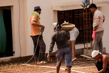 MUMBAI, MAHARASHTRA, INDIA 12 Kasım 2019: İnşaat işçileri bir inşaat sahasında çalışıyor. Hindistan 'da inşaat işçileri iş yerinde güvenlik önlemi almıyorlar..