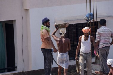 MUMBAI, MAHARASHTRA, INDIA 12 Kasım 2019: İnşaat işçileri bir inşaat sahasında çalışıyor. Hindistan 'da inşaat işçileri iş yerinde güvenlik önlemi almıyorlar..