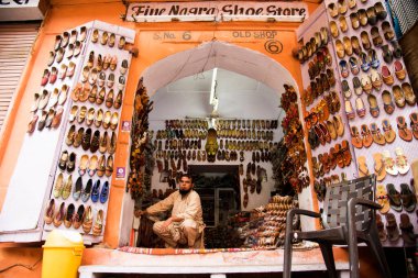 JAIPUR, INDIA, 12 Ağustos 2019: Hindistan 'ın Jaipur kentindeki Hawa Mahal' in yeni restore edilmiş ön cephesinin dışındaki pazar yerinde çeşitli mallar satan sokak satıcısı