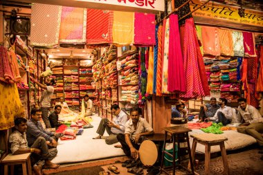 JAIPUR, INDIA 13 AĞUSTOS 2019: Geleneksel sari ve kumaş satan tüccarlar, Jaipur, Jaipur, Hindistan 'ın geleneksel doğu el sanatları merkezidir
