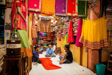 JAIPUR, INDIA 13 AĞUSTOS 2019: Geleneksel sari ve kumaş satan tüccarlar, Jaipur, Jaipur, Hindistan 'ın geleneksel doğu el sanatları merkezidir