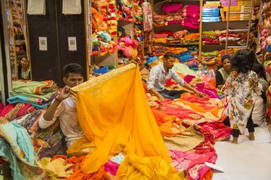 JAIPUR, INDIA 13 AĞUSTOS 2019: Geleneksel sari ve kumaş satan tüccarlar, Jaipur, Jaipur, Hindistan 'ın geleneksel doğu el sanatları merkezidir