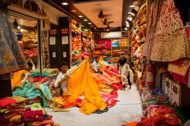 JAIPUR, INDIA 13 AĞUSTOS 2019: Geleneksel sari ve kumaş satan tüccarlar, Jaipur, Jaipur, Hindistan 'ın geleneksel doğu el sanatları merkezidir