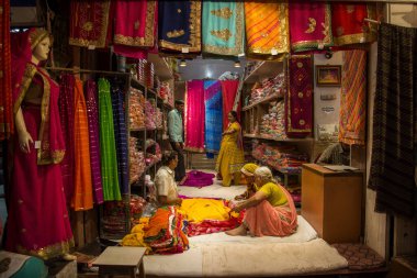 JAIPUR, INDIA 13 AĞUSTOS 2019: Geleneksel sari ve kumaş satan tüccarlar, Jaipur, Jaipur, Hindistan 'ın geleneksel doğu el sanatları merkezidir