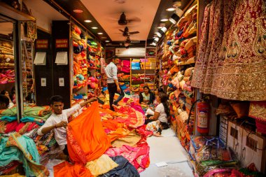 JAIPUR, INDIA 13 AĞUSTOS 2019: Geleneksel sari ve kumaş satan tüccarlar, Jaipur, Jaipur, Hindistan 'ın geleneksel doğu el sanatları merkezidir