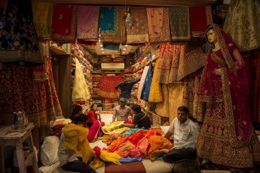 JAIPUR, INDIA 13 AĞUSTOS 2019: Geleneksel sari ve kumaş satan tüccarlar, Jaipur, Jaipur, Hindistan 'ın geleneksel doğu el sanatları merkezidir