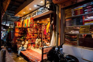JAIPUR, INDIA 13 AĞUSTOS 2019: Geleneksel sari ve kumaş satan tüccarlar, Jaipur, Jaipur, Hindistan 'ın geleneksel doğu el sanatları merkezidir