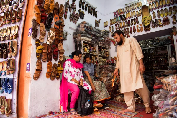 JAIPUR, INDIA, 12 Ağustos 2019: Hindistan 'ın Jaipur kentindeki Hawa Mahal' in yeni restore edilmiş ön cephesinin dışındaki pazar yerinde çeşitli mallar satan sokak satıcısı