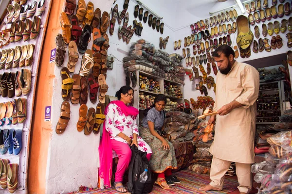 JAIPUR, INDIA, 12 Ağustos 2019: Hindistan 'ın Jaipur kentindeki Hawa Mahal' in yeni restore edilmiş ön cephesinin dışındaki pazar yerinde çeşitli mallar satan sokak satıcısı