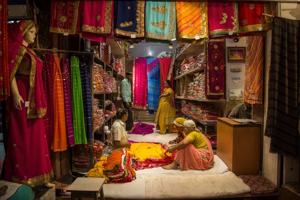 JAIPUR, INDIA 13 AĞUSTOS 2019: Geleneksel sari ve kumaş satan tüccarlar, Jaipur, Jaipur, Hindistan 'ın geleneksel doğu el sanatları merkezidir