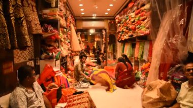 JAIPUR, INDIA 13 AĞUSTOS 2019: Geleneksel sari ve kumaş satan tüccarlar, Jaipur, Jaipur, Hindistan 'ın geleneksel doğu el sanatları merkezidir