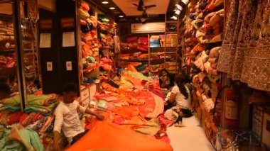 JAIPUR, INDIA 13 AĞUSTOS 2019: Geleneksel sari ve kumaş satan tüccarlar, Jaipur, Jaipur, Hindistan 'ın geleneksel doğu el sanatları merkezidir