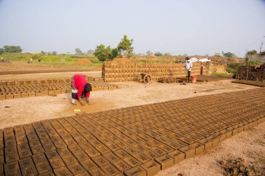 AURANGABAD, MAHARASHTRA, INDIA, 26 Kasım 2019: Kalıplardan ıslak kil tuğlalar yapan Hintli işçiler açık havada güneş ışığında kurutmak için elle kil tuğlalar yapıyorlar.