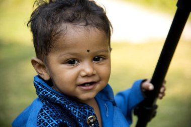 Şirin bir Hintli çocuk bahçede mutlu bir şekilde oynuyor..