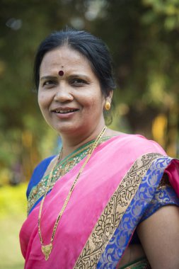 Geleneksel olarak giyinmiş Hint kökenli bir kadının portresi.