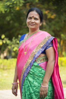 Geleneksel olarak giyinmiş Hint kökenli bir kadının portresi.