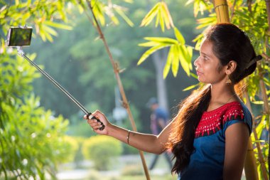 Güzel genç kız selfie çekiyor selfie çubuğuyla.