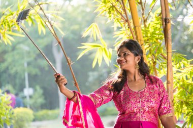 Güzel genç kız selfie çekiyor selfie çubuğuyla.