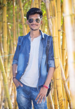 Bambu arka planında yakışıklı, mutlu genç bir adam..