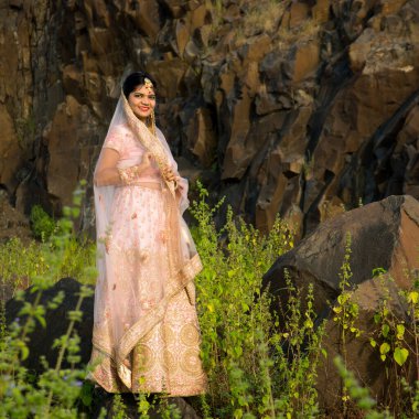 Açık havada geleneksel gelinlik içinde güzel bir Hintli gelin..