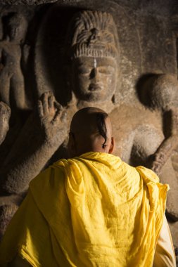 Keşiş Buda heykelinin önünde antik mağarada
