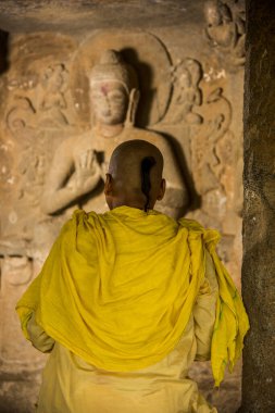 Keşiş Buda heykelinin önünde antik mağarada