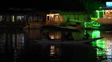 SRINAGAR, KASHMIR, INDIA, 15 Temmuz 2024: Dal Gölü 'nde bir akşam, insanlar geleneksel Shikara teknesinde eğleniyor.