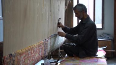 SRINAGAR, INDIA, 28 HAZİRAN 2024 Kashmiri adam elle dokuma makinesi ile bir halı örüyor, Kaşmir halısı dünyada meşhurdur.