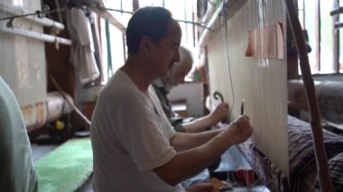 SRINAGAR, INDIA, 28 HAZİRAN 2024 Kashmiri adam elle dokuma makinesi ile bir halı örüyor, Kaşmir halısı dünyada meşhurdur.