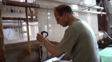 SRINAGAR, INDIA, 28 HAZİRAN 2024 Kashmiri adam elle dokuma makinesi ile bir halı örüyor, Kaşmir halısı dünyada meşhurdur.