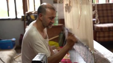 SRINAGAR, INDIA, 28 HAZİRAN 2024 Kashmiri adam elle dokuma makinesi ile bir halı örüyor, Kaşmir halısı dünyada meşhurdur.