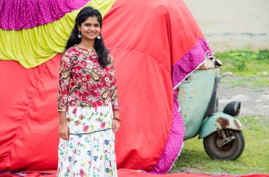 Renkli perdelerin önünde güzel bir Hintli kız.