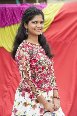 Renkli perdelerin önünde güzel bir Hintli kız.
