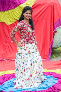 Renkli perdelerin önünde güzel bir Hintli kız.