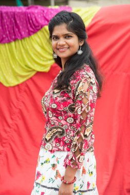 Renkli perdelerin önünde güzel bir Hintli kız.