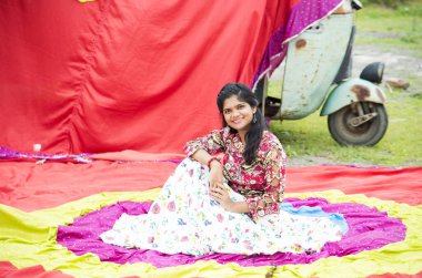 Renkli perdelerin önünde güzel bir Hintli kız.