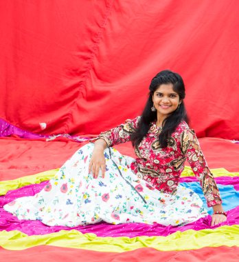 Renkli perdelerin önünde güzel bir Hintli kız.