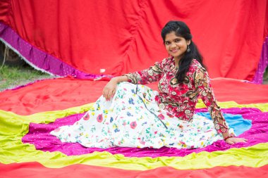 Renkli perdelerin önünde güzel bir Hintli kız.