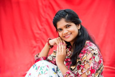 Renkli perdelerin önünde güzel bir Hintli kız.