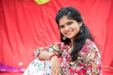 Renkli perdelerin önünde güzel bir Hintli kız.