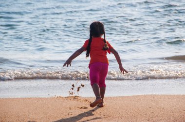 Güzel küçük kız kumlu sahilde oynuyor, Goa, Hindistan,