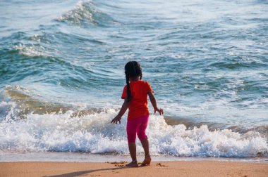 Güzel küçük kız kumlu sahilde oynuyor, Goa, Hindistan,