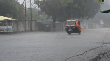AMRAVATI, MAHARASHTRA, INDIA 7 AĞUSTOS 2017: Gündüz vakti yoğun sağanak altında trafik.