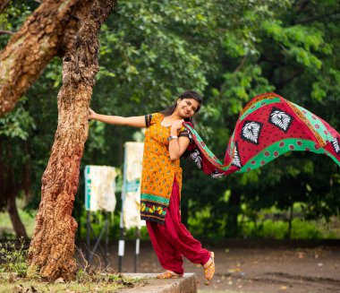 Ağaç gövdesinin yanında genç bir kız ve açık havanın tadını çıkarıyor.