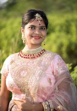 Doğada geleneksel kıyafetler giyen güzel bir gelin portresi..